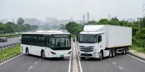 Electric bus and electric truck with green EV number plates on a Delhi-NCR highway, representing the PARIVARTAN old vehicle replacement scheme
