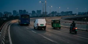 Electric bus, delivery van, auto-rickshaw and scooter on an Indian flyover at dusk, representing India's EV ecosystem report 2026