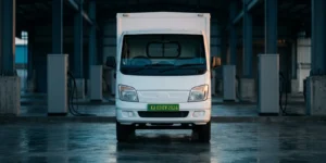 Electric light commercial vehicle with a green number plate in a depot bay, illustrating electric vehicle finance for Indian fleets